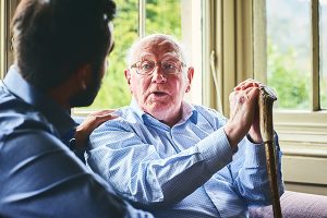 Elderly man talking with doctor at home